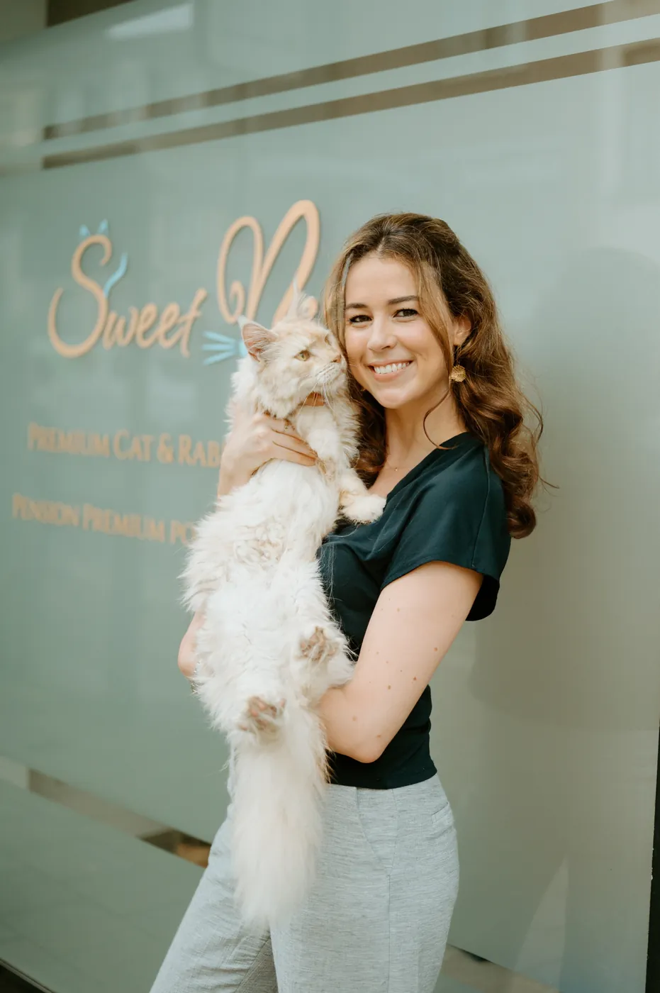 Saskia, founder of Sweetnest, holding a white cat